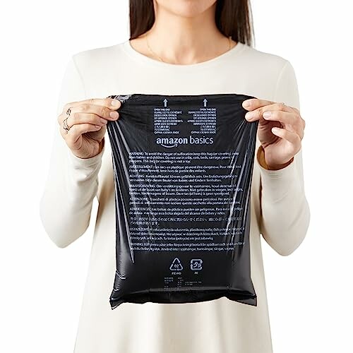 Person holding Amazon Basics battery package, showcasing the product's convenience.