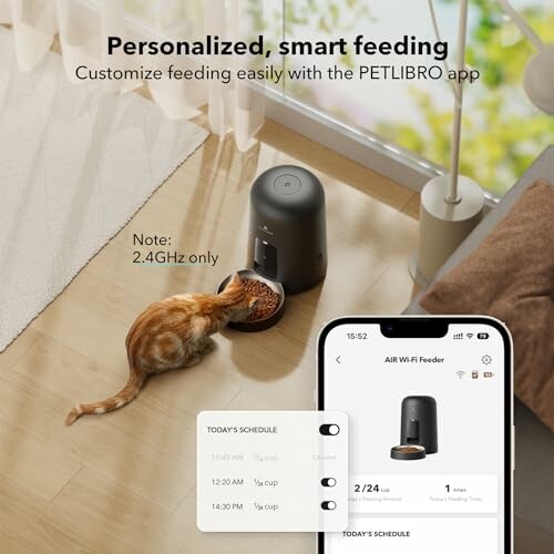 Cat eating from smart pet feeder controlled by app.